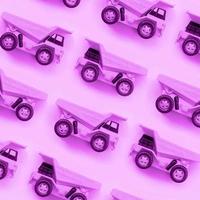 många små lila leksak lastbilar på textur bakgrund av mode pastell lila Färg papper foto