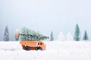 jul träd på leksak bil lastbil var löpning genom de snö i de fält av naturlig landskap bakgrund foto