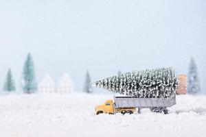 jul träd på leksak bil lastbil var löpning genom de snö i de fält av naturlig landskap bakgrund foto