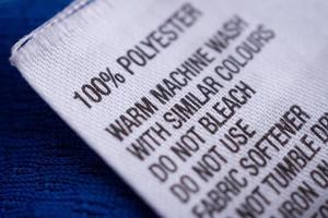 klädesetikett i polyester med tvättanvisningsetikett på blå tröja foto