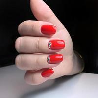 närbild Foto av en skön kvinna händer med röd nagel