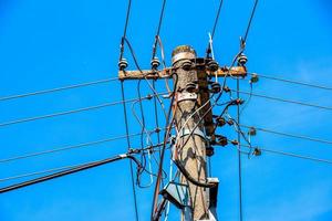 elektrisk Pol kraft rader utgående elektrisk trådar motstånd på moln blå himmel. foto