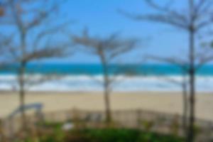suddig bakgrund, se tropisk strand med Sol ljus Vinka abstrakt bakgrund. resa begrepp. foto