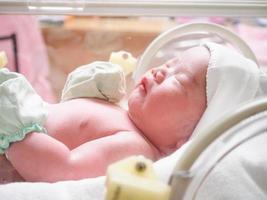 nyfödd bebis spädbarn sömn i de inkubator på sjukhus foto