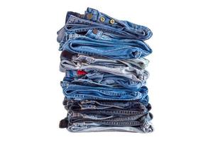 lugg av denim blå jeans stack isolerat på vit bakgrund foto