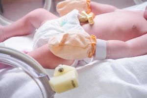 nyfödd flicka bebis inuti inkubator i sjukhus med Identifiering armband märka namn foto