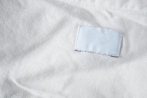 vit tom tvättvård kläder etikett på bomull skjorta foto