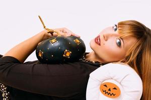 ung kvinna med svart pumpa i halloween dekoration foto