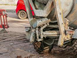 mobil betong mixer på de konstruktion webbplats. närbild av grus varelse lastad in i en betong framställning maskin foto