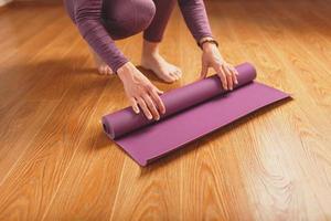 ben och händer av en kvinna på en yoga matta praktiserande asanas foto