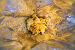närbild se inuti av en stor silver- väska av potatis pommes frites med selektiv fokus foto
