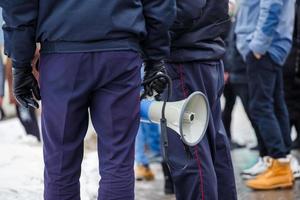 polis officer innehav högtalare megafon utomhus, närbild foto