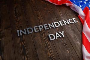 de ord oberoende dag lagd på brun trä- plankor yta med skrynkliga förenad stater av Amerika flagga foto