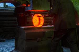 närbild bild av varm stål manuell smide bearbeta med stor mekanisk hammare maskin foto