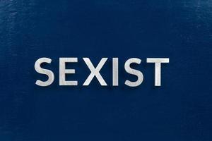 de ord sexist lagd med vit brev på mörk blå platt bakgrund foto