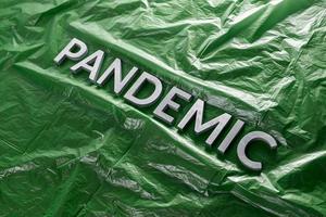 de ord pandemi lagd med silver- brev på skrynkliga grön plast filma - diagonal perspektiv sammansättning med selektiv fokus foto