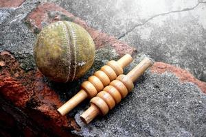cricket sport utrustning på tegel, fladdermus, grind, gammal läder boll, mjuk och selektiv fokus. foto