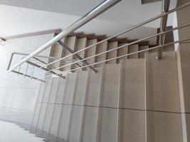 modern design av stanless stål rör ledstång och keramisk plattor trappa i abstrakt offentlig byggnad foto