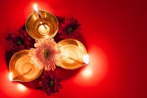 Lycklig diwali. traditionell hindu firande. diya olja lampor och blommor på röd bakgrund. religiös Semester av ljus. foto