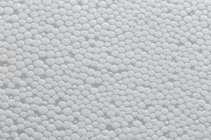 enkel närbild platt men ojämn bakgrund av vit polystyren skum eller Frigolit, vit på vit bakgrund med selektiv fokus och partiell fläck. foto