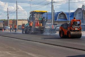 tula, ryssland Maj 16, 2021 bearbeta av asfaltering, asfalt utläggare maskin och väg vält under väg konstruktion Arbetar, i sommar dag foto