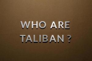 de fråga vem är taliban lagd med silver- metall brev på grov solbränna kaki duk tyg foto