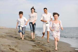 Lycklig ung familj ha roligt på strand foto