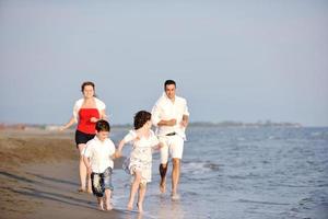 Lycklig ung familj ha roligt på strand foto