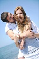 lyckliga unga par ha kul på stranden foto