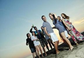 grupp av ung människor njut av sommar fest på de strand foto