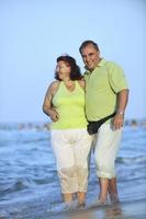 Lycklig seniors par på strand foto