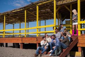 grupp av vänner har roligt på höst dag på strand foto