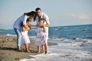 Lycklig ung familj ha roligt på strand foto