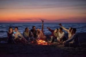 en grupp av vänner njuter bål på strand foto