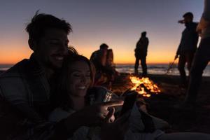 par njuter bål med vänner på strand foto