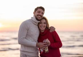 par kramas och dricka öl tillsammans på de strand foto