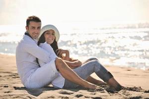 Lycklig ung par ha roligt på skön strand foto