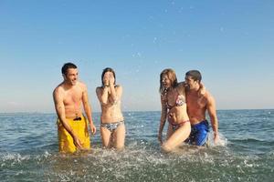 Lycklig ung människor grupp ha roligt på strand foto