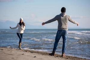 kärleksfull ung par på en strand på höst solig dag foto