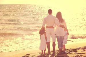 Lycklig ung familj ha roligt på strand foto