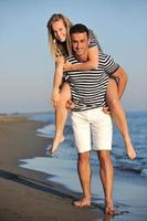 Lycklig ung par ha romantisk tid på strand foto