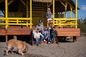 grupp av vänner har roligt på höst dag på strand foto