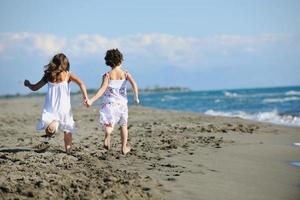 söt liten flickor löpning på strand foto