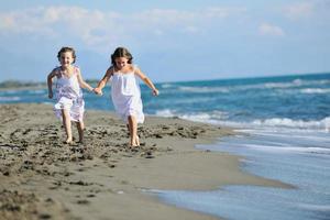 söt liten flickor löpning på strand foto
