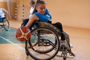 en ung kvinna spelar rullstol basketboll i en professionell team. kön jämlikhet, de begrepp av sporter med funktionshinder. foto