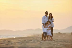 Lycklig ung familj ha roligt på strand foto