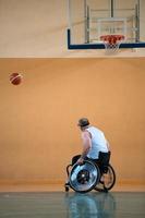 en krig ogiltig i en rullstol tåg med en boll på en basketboll klubb i Träning med professionell sporter Utrustning för de Inaktiverad. de begrepp av sport för människor med funktionshinder foto