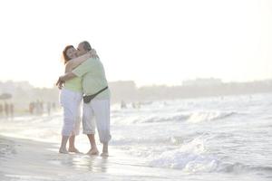 Lycklig seniors par på strand foto