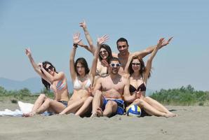 grupp av Lycklig ung människor i ha roligt på strand foto