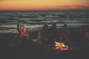 en grupp av vänner njuter bål på strand foto